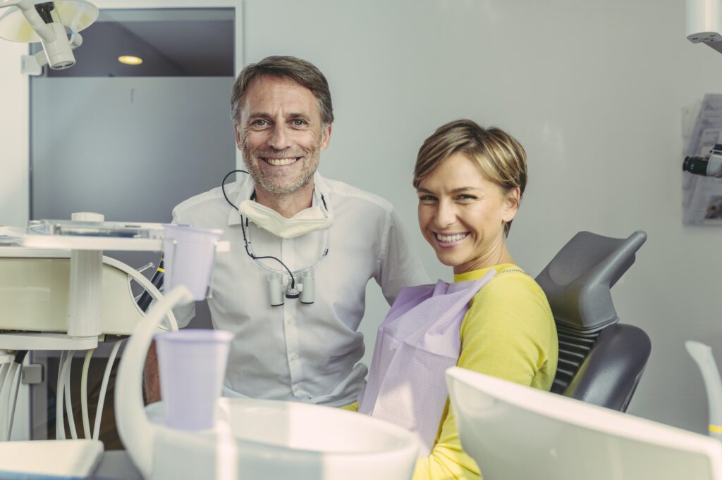 Dentist and patient smiling at camera, portrait